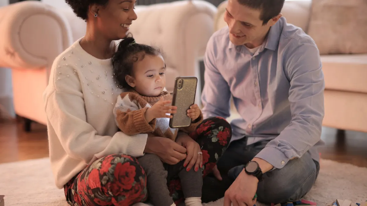 Parents and child gathered around a smartphone